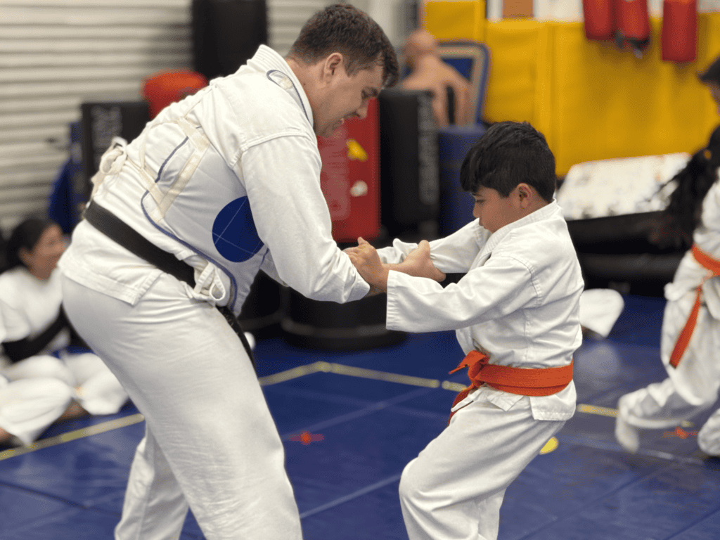 kid practicing self defense with instructor
